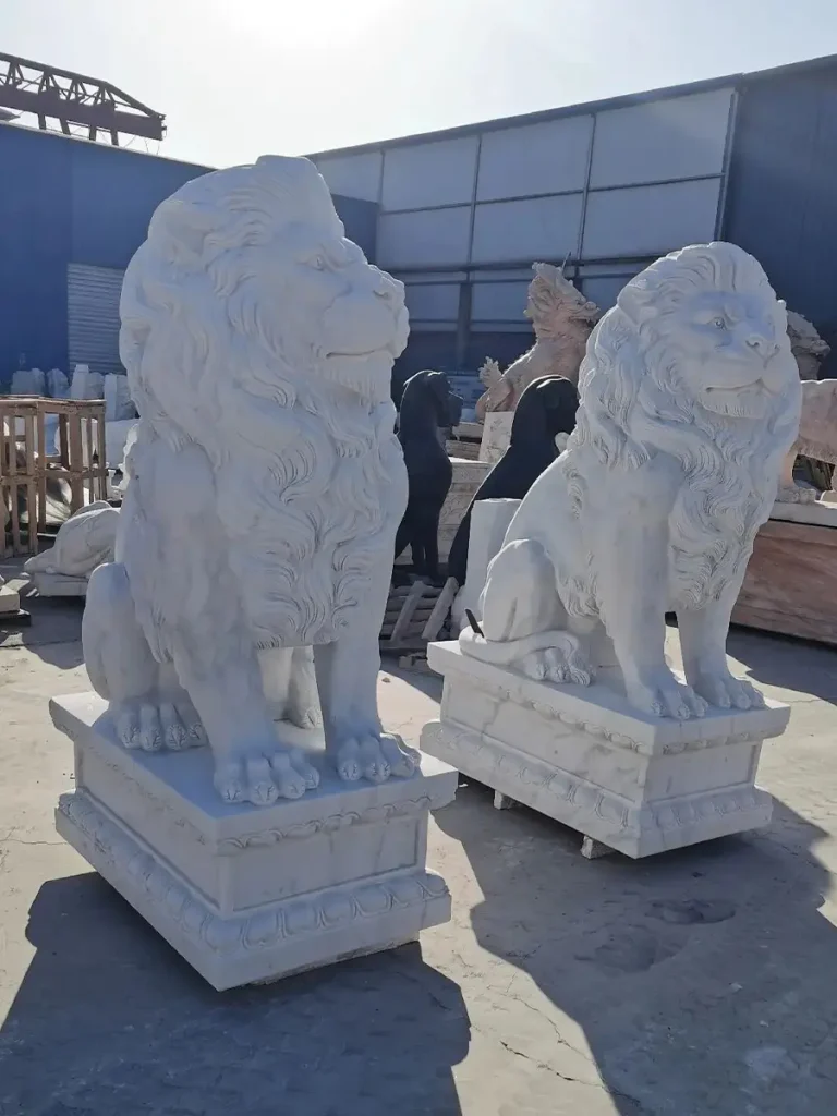A matching pair of large, European-style white marble lion statues sitting proudly on rectangular pedestals. Placed together, these appropriately proportioned guardian sculptures are ideal for creating a clear spatial hierarchy and a dramatic "gateway effect" at a luxury estate.