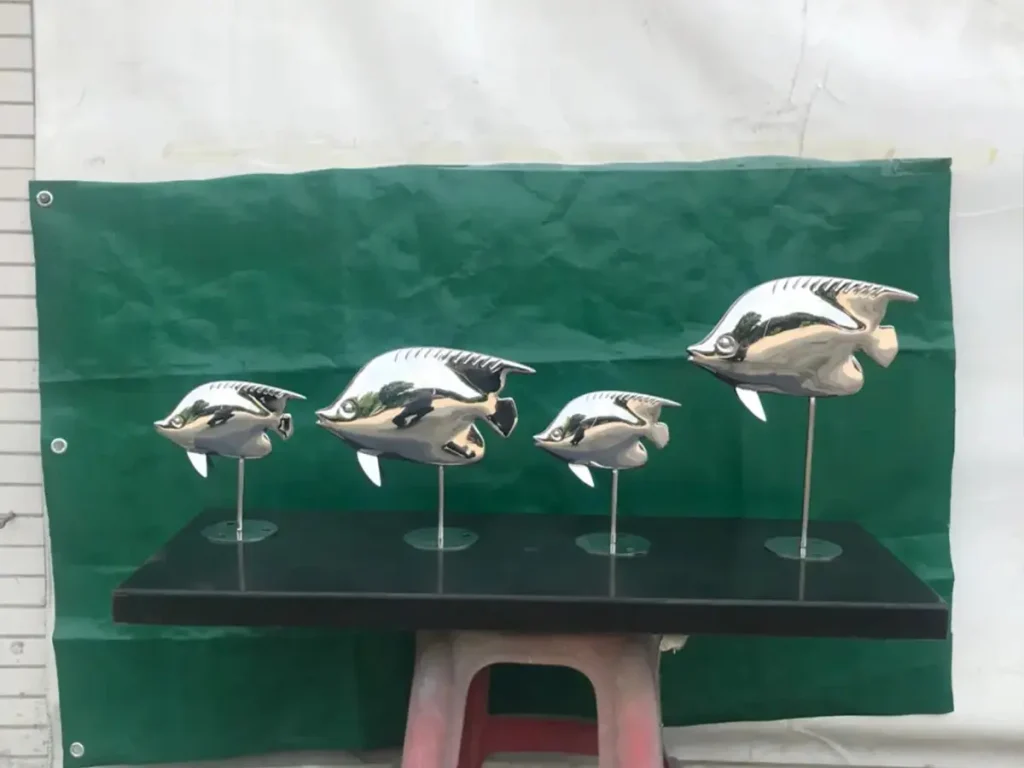 A beautiful set of four polished stainless steel tropical fish sculptures mounted on thin invisible rods. Ideal for placing along shallow reflecting pools, these artworks amplify the illusion of swimming aquatic life through brilliant light reflection.