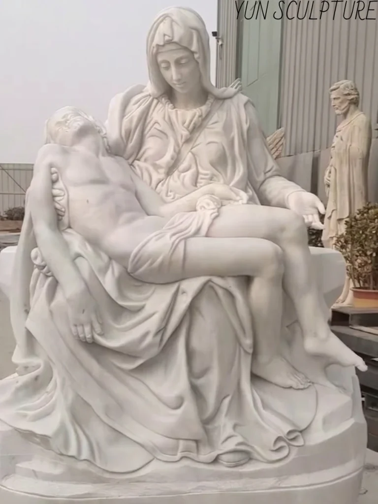 Full view of a white marble Pietà statue inspired by Michelangelo, depicting Mary holding the adult Jesus with architectural drapery and balanced proportions.