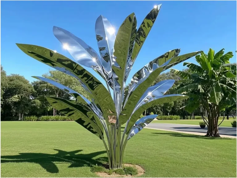 A breathtaking mirror-polished stainless steel tropical tree sculpture standing as a monumental focal point on a lush green lawn. Serving as the featured image for our comprehensive guide on custom metal tree and plant sculptures, this brilliant artwork perfectly captures the "Liquid Silver" effect, flawlessly reflecting the bright sky and natural surroundings to elevate modern landscape design.