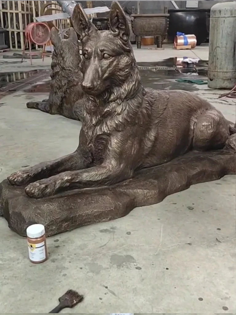 Side profile of the life-size bronze German Shepherd, showcasing the smooth finish and realistic resting posture for garden or K-9 memorials.
