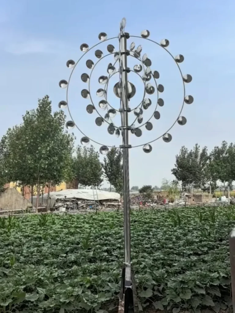An outdoor kinetic wind sculpture featuring concentric rings, engineered with Molybdenum-enhanced 316L steel to withstand chloride corrosion in humid environments.