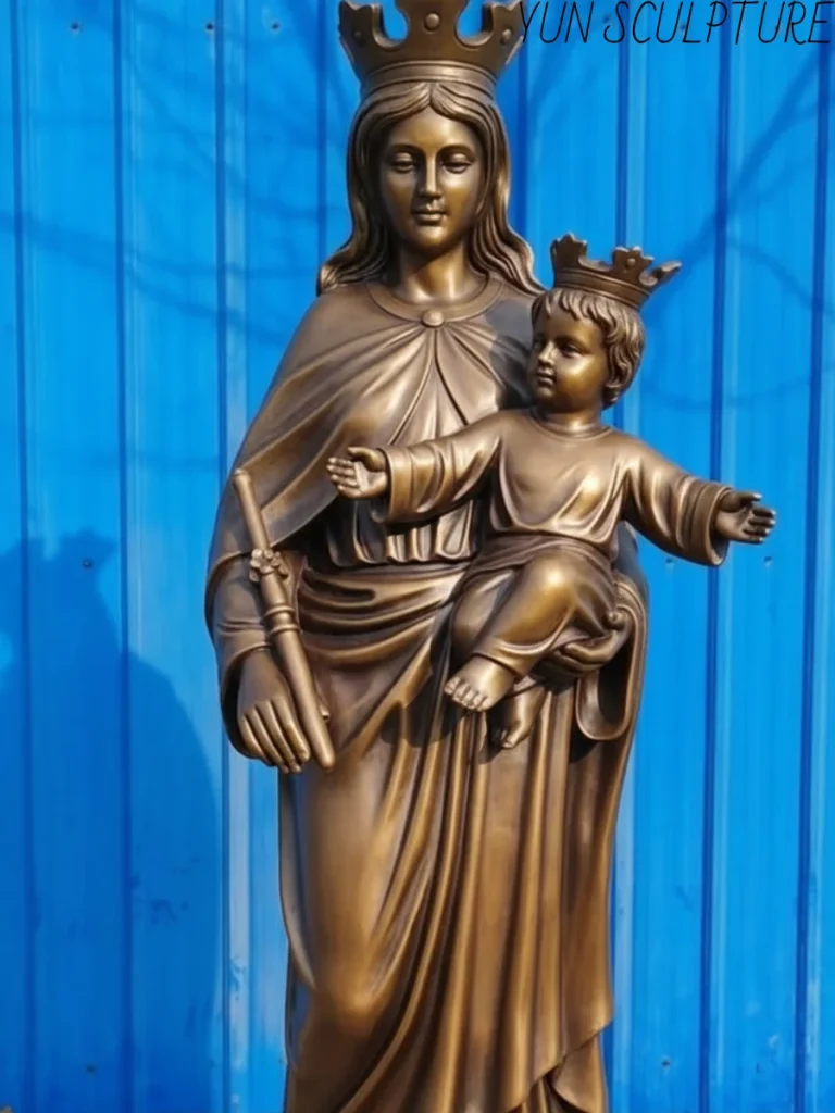 A bronze Virgin Mary statue with baby Jesus, where the Christ child is depicted with a hand raised in blessing, symbolizing the theological moment of the Incarnation.