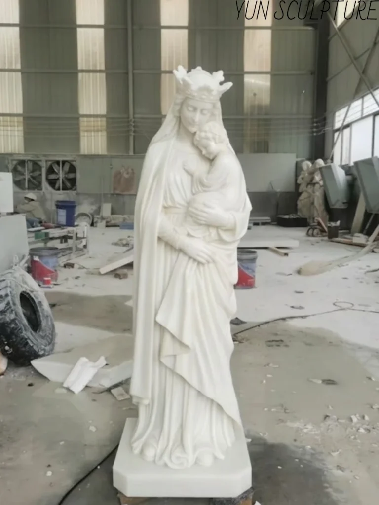 A handcrafted white marble Madonna and Child statue, demonstrating precise infant anatomical proportions and the soft facial features of baby Jesus.