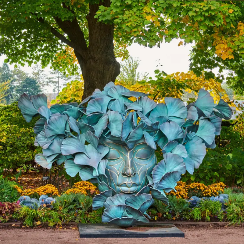 Finished bronze flower sculpture with vibrant blue-green chemical patina coloring