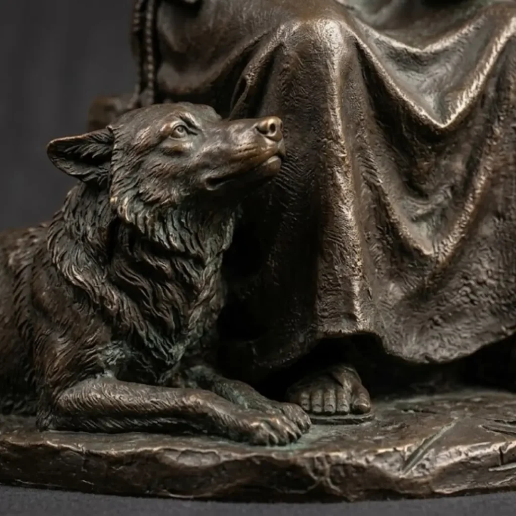 Detailed close-up of a bronze wolf sitting calmly at the feet of St. Francis, symbolizing the story of the Wolf of Gubbio and the theme of peace and reconciliation.
