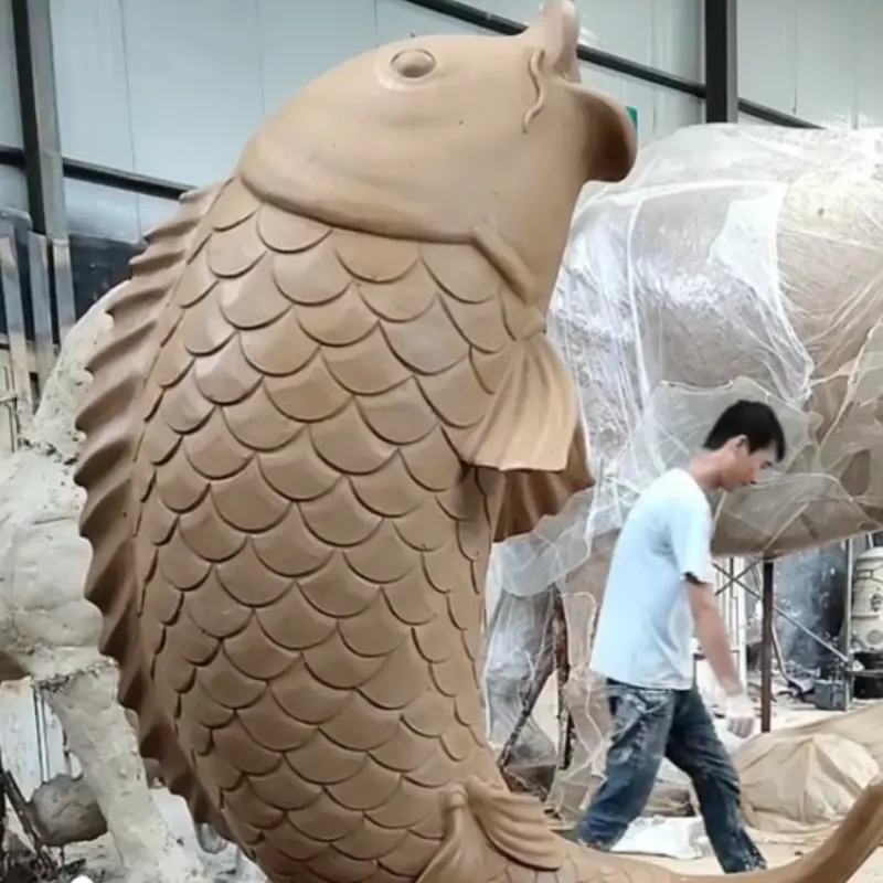 Worker building large clay fish sculpture model at Yun Sculpture factory