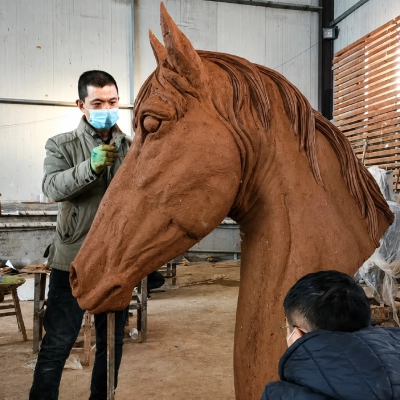 Hand-sculpted clay model of horse head in Yun Sculpture workshop