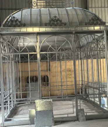 Galvanized iron lean-to greenhouse frame showing structural joints and glass panel slots