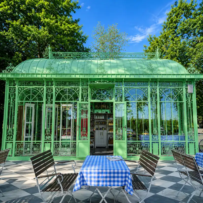 Green Victorian wrought iron conservatory with ornate domed roof and scrollwork