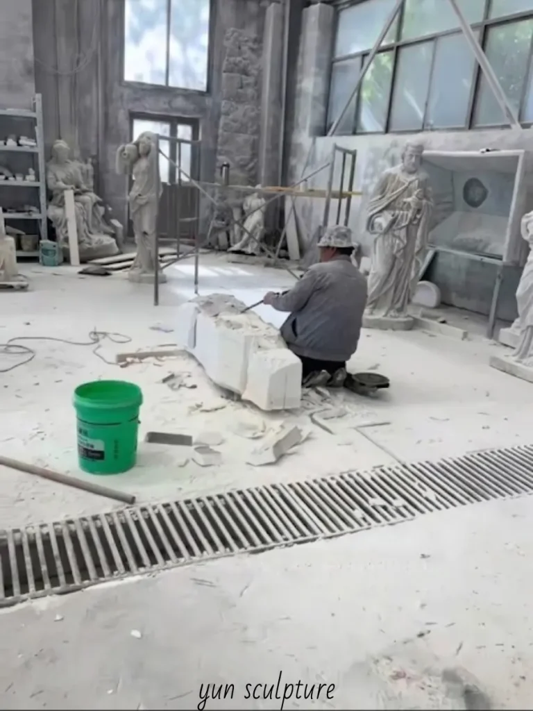 A sculptor roughing out the silhouette of an Immaculate Heart of Mary statue in a dusty workshop, beginning the arduous physical process of carving her profound interior life and maternal care into enduring stone.