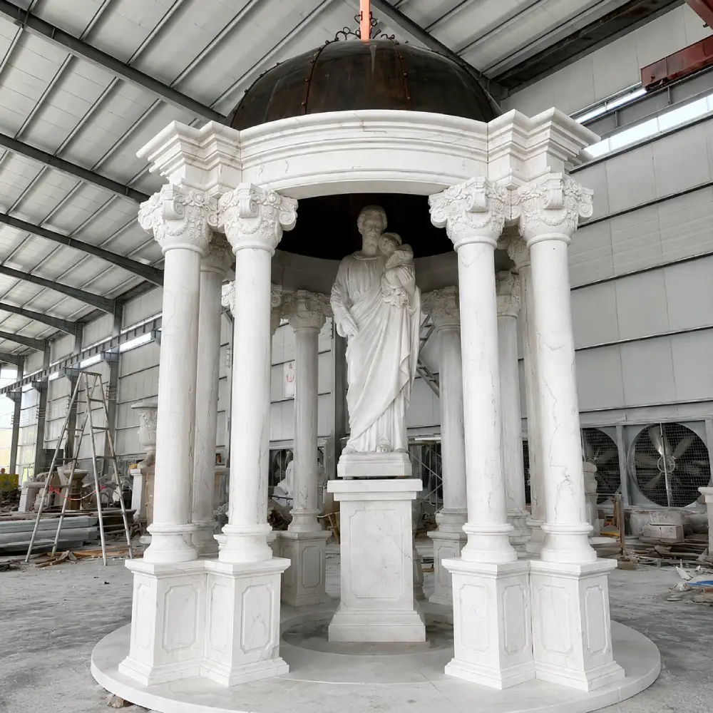 A majestic white marble gazebo shrine with a central St. Joseph statue and Corinthian columns. The natural white marble creates a luminous and sacred atmosphere, ideal for a chapel garden or sheltered church interior as described in our guide.