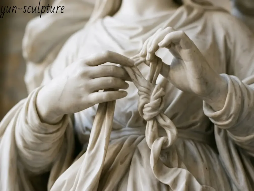 A close-up of Yun Sculpture's white marble Mary Undoer of Knots in production, showing hands precisely untying a knotted ribbon, echoing Schmidtner's original 1700 composition.