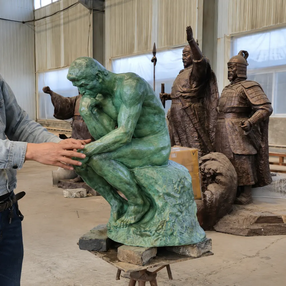 A mid-scale (80cm to 120cm) bronze Thinker statue with a striking green patina during a final inspection. This size is specifically designed for private estate gardens, where it functions best at an axis point, facing inward to create a sense of discovery for visitors as explained in our garden design guide.