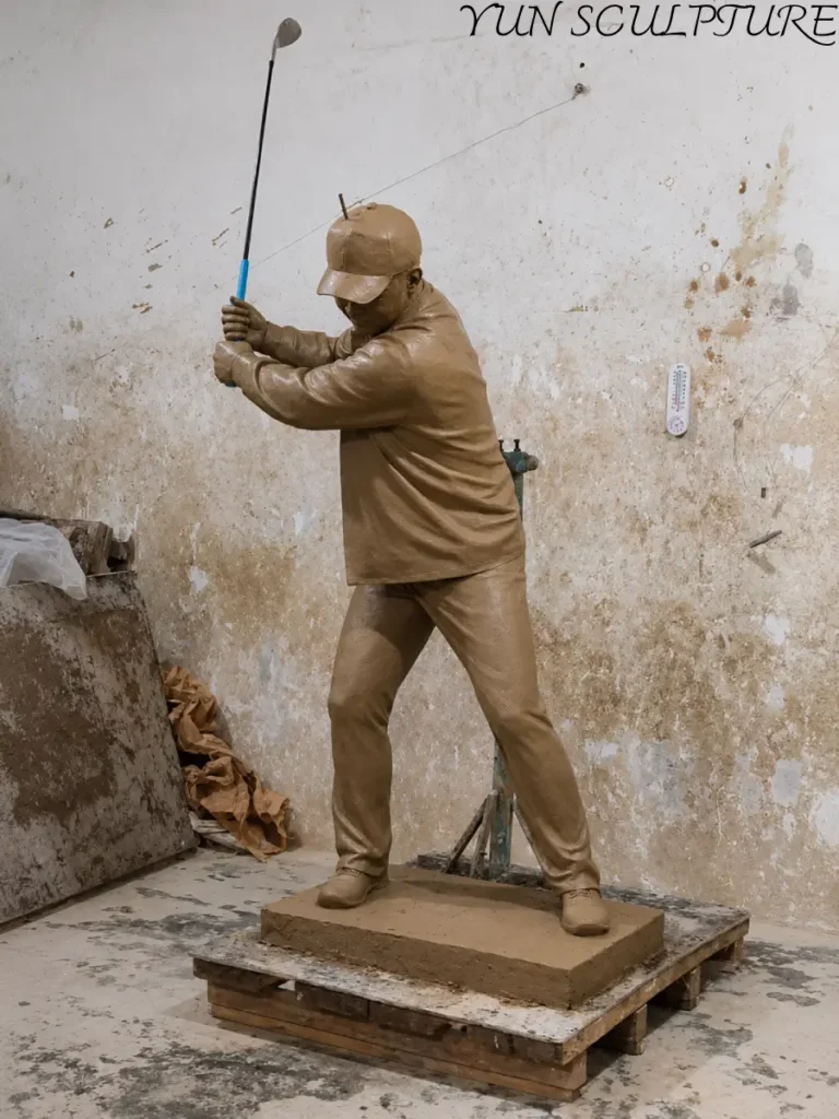 Side view of a hand-sculpted clay original for a bronze golf statue, focusing on the upright and classical swing posture that reflects the aesthetic of the early 20th century.
