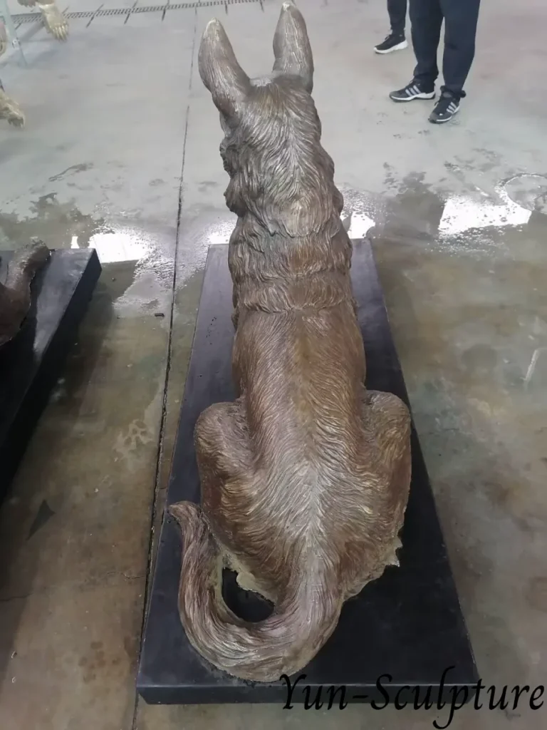 A back view of a custom life-size bronze German Shepherd statue in a seated pose. This living portrait captures the detailed coat texture and realistic proportions, serving as a permanent tribute of appreciation for a loyal companion.