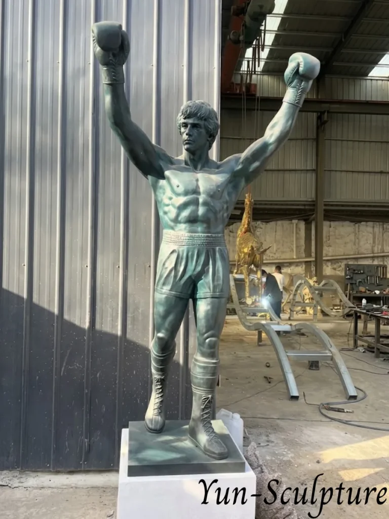 A life-size bronze portrait commission of Sylvester Stallone as Rocky Balboa, standing in his iconic victory pose with arms raised. This project demonstrates Yun Sculpture’s expertise in likeness commissions, capturing exact facial features and muscular anatomy through professional clay modeling and lost-wax casting.