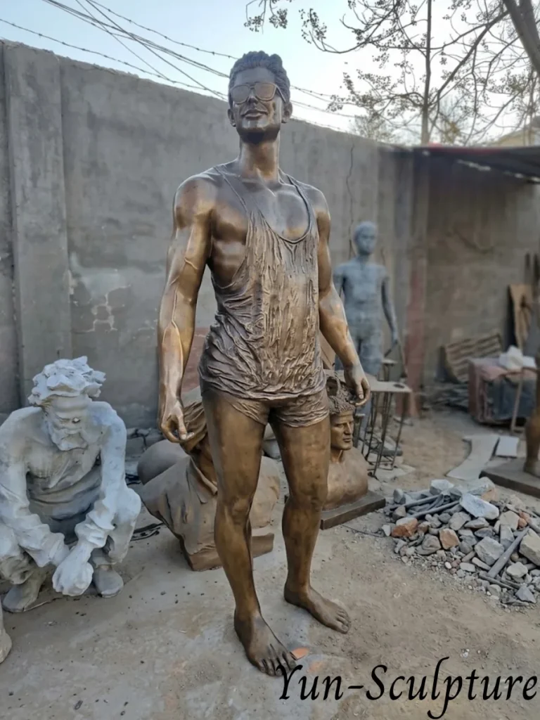 A life-size (170-185 cm) custom bronze portrait statue of a man in casual attire and sunglasses, standing in the Yun Sculpture foundry. This piece exemplifies our high-fidelity likeness commissions and custom pose figures, crafted within 30-50 working days using professional lost-wax casting.
