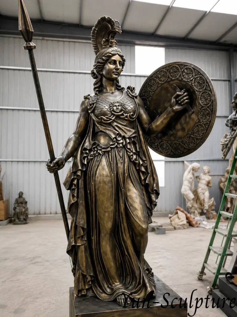 A majestic life-size bronze Athena statue in full armor with a spear and Gorgon shield. This presiding figure is engineered to elevate the intellectual register of formal spaces like law firms, libraries, or academic institutions through its serious and commanding presence.