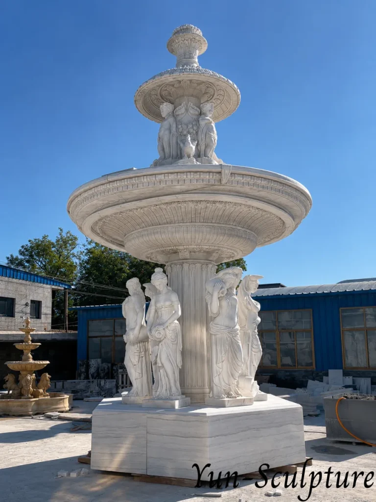A monumental three-tier white marble garden fountain with multiple hand-carved deity statues at the base. This architectural masterpiece provides a powerful focal point for estates or coastal gardens, ensuring the mythological presence of Venus is correctly integrated with the surrounding space.