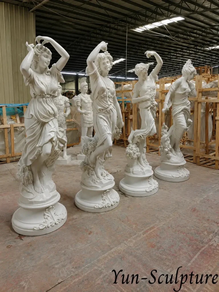 An interior view of our workshop showing multiple life-size female deity statues. The intricate carving of the flowing robes and the bared shoulders illustrates the technical accomplishment and aesthetic choices available for custom garden or institutional commissions.