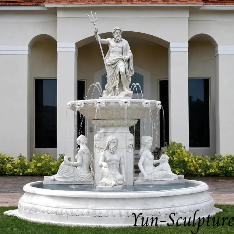 A monumental three-tier white marble fountain featuring the Greek God Poseidon at the summit, trident in hand, and seated mythological figures at the base. Installed at a luxury estate entrance, this hand-carved masterpiece communicates the "sovereign force" and ancient authority of Poseidon over water features, as described in our placement guide.