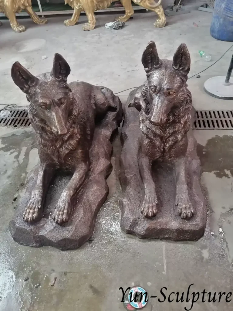 A pair of life-size bronze German Shepherd statues in a reclining position, hand-cast at Yun Sculpture. These pieces illustrate the high fidelity of our pet portrait commissions, created as acts of appreciation for still-present family members.