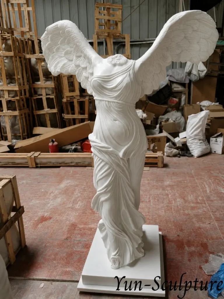 A life-size white marble replica of the Winged Victory of Samothrace (Nike) in our workshop. Given the structural complexity and leverage stress of the feathered wings, this marble version is ideal for sheltered interior display or covered garden niches as described in our guide.
