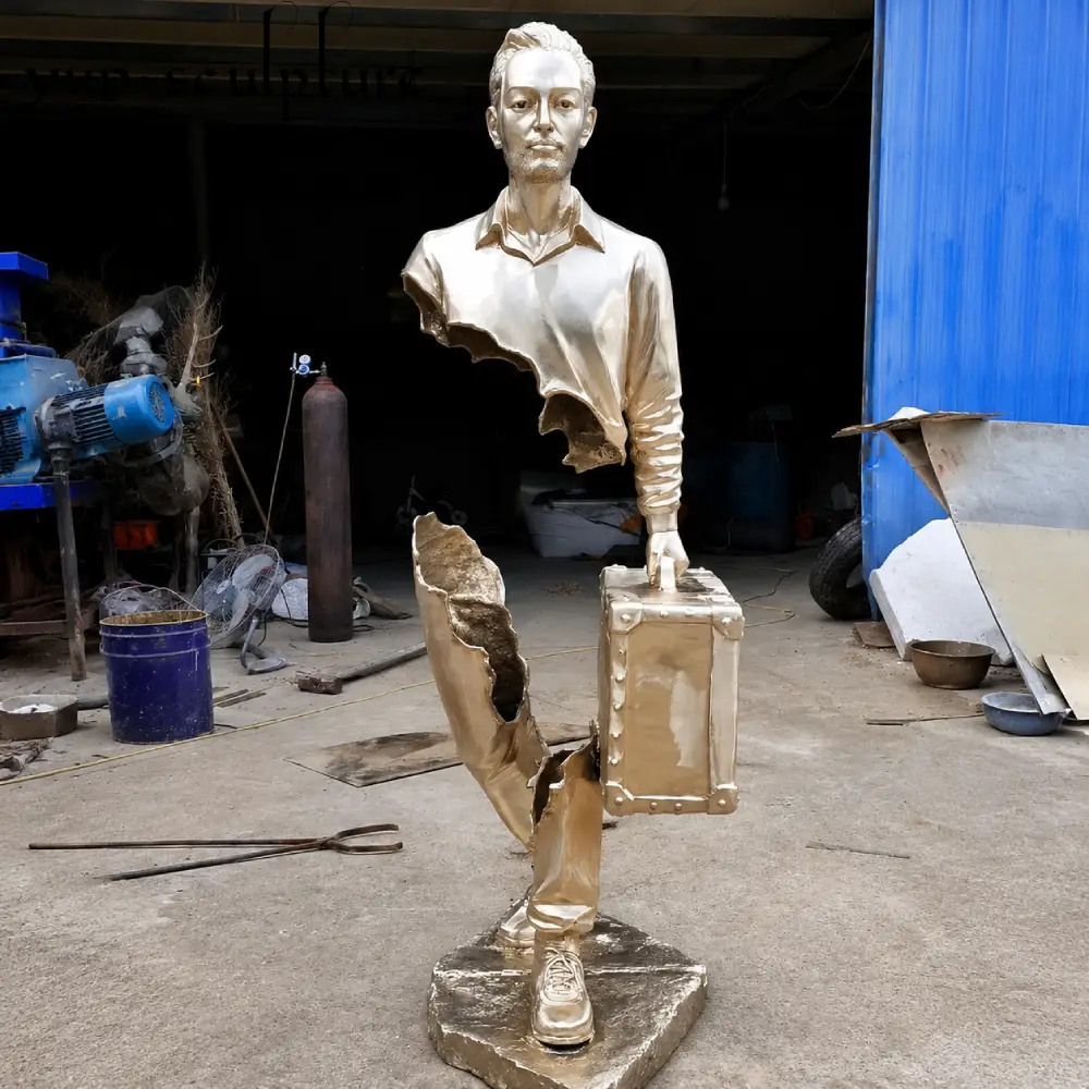 A life-size custom bronze traveler statue with a polished gold finish, showcasing a unique surrealist design with missing torso sections. This masterpiece, created at the Yun Sculpture foundry, represents our "Custom Commission" service, where clay models are built from scratch to achieve artistic designs that cannot be found in a standard catalog.