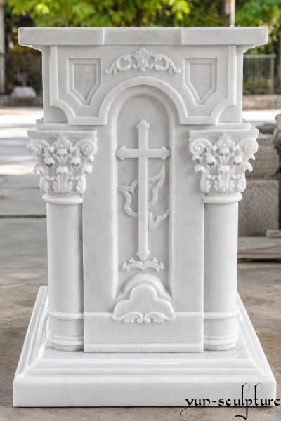 A hand-carved solid natural white marble church altar table featuring a central cross relief and ornate Corinthian pillars. Designed as the heart of the sanctuary, this majestic stone piece commands respect and is ideal for Catholic church renovations or new cathedral projects, matching our expert liturgical design standards.