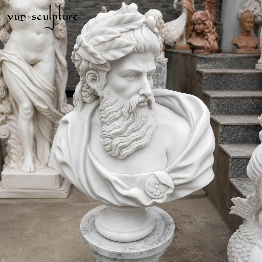 A hand-carved natural white marble bust of a bearded Greek god, possibly Zeus, wearing a laurel wreath. Mounted on a matching white marble pedestal, this classical sculpture illustrates the ideal contrast and "luminous" quality for indoor installations in libraries, offices, or institutional honor walls as discussed in our guide.