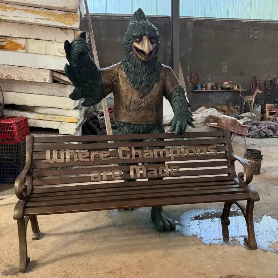 Front view of the finished bronze bluebird sculpture with the custom bench during final factory inspection.