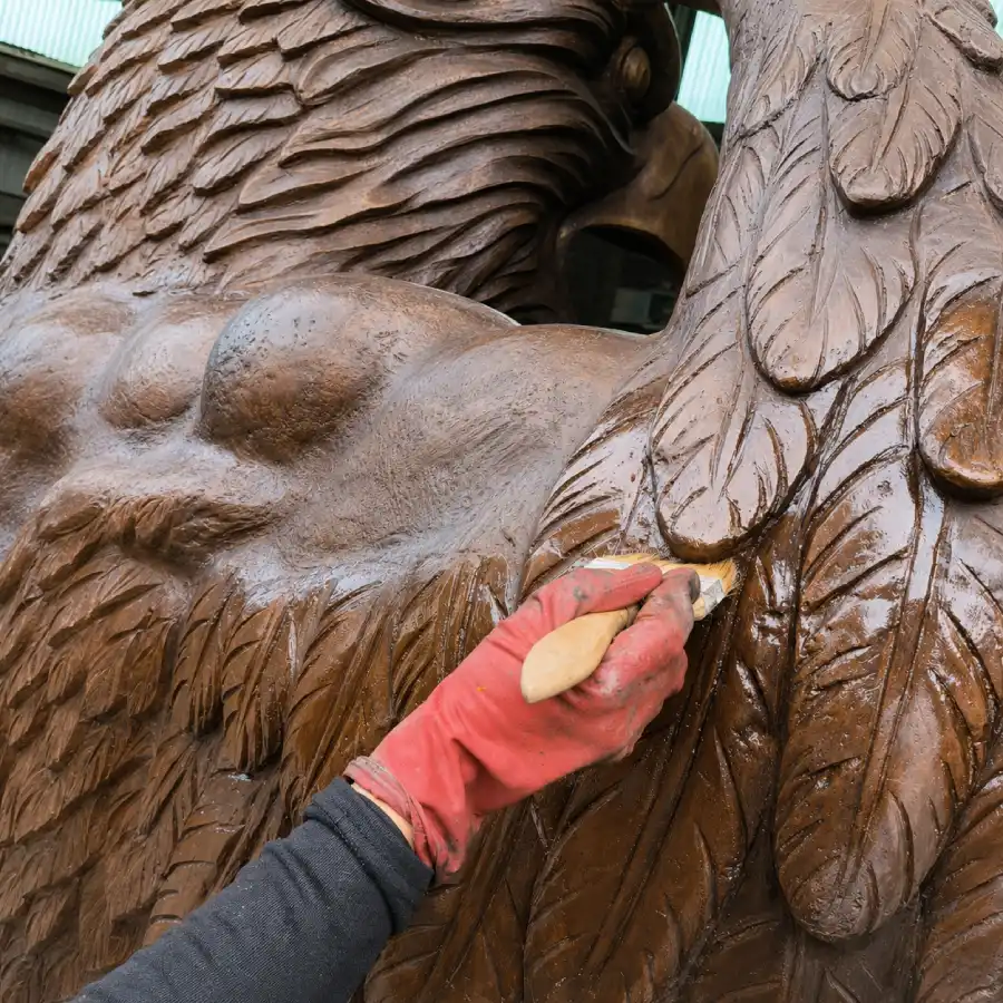 Hand application of patina to the feather details of the custom bronze bluebird sculpture