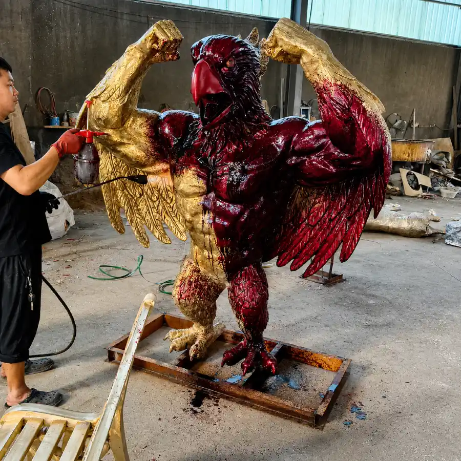 Patina coloring in progress on the custom bronze bluebird sculpture using layered surface treatments.
