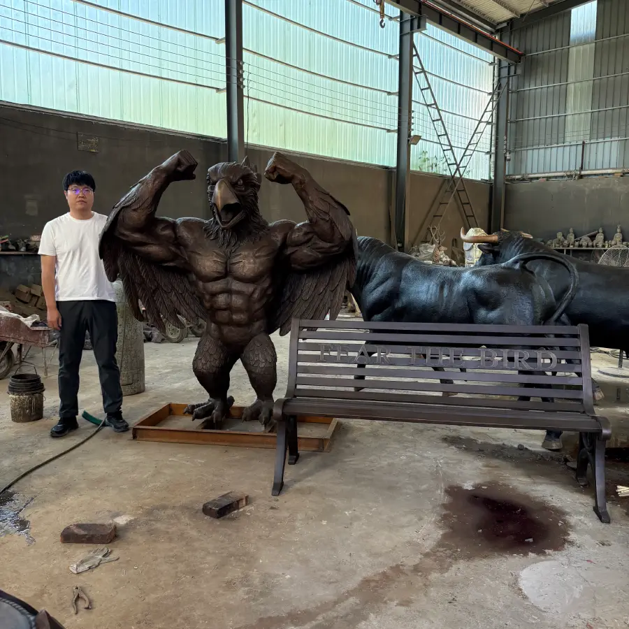 Completed bronze bluebird sculpture and bench shown with a person for size and proportion reference before shipping.