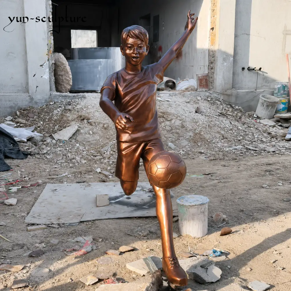 A life-size custom bronze football player statue in a dynamic kicking pose, hand-cast at the Yun Sculpture foundry. This generic athletic figure represents our premium quality tier for outdoor sports sculptures, offered at factory-direct pricing for schools and stadiums.