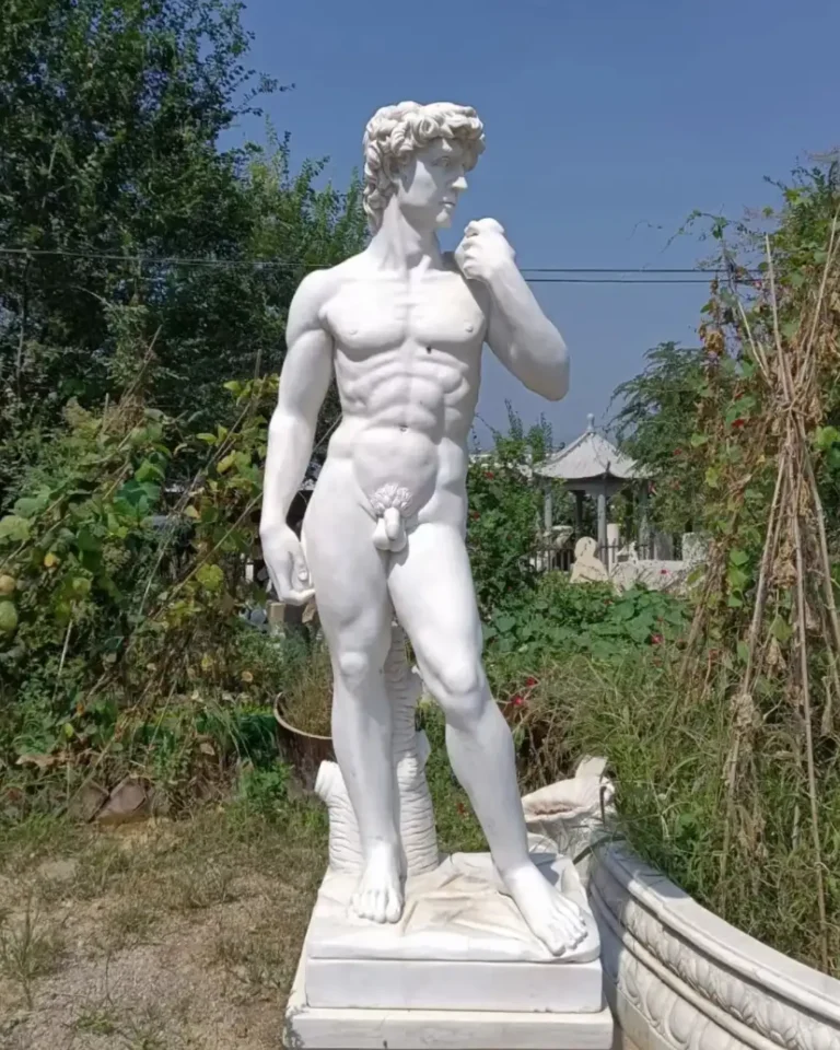 A life-size, hand-carved natural white marble replica of Michelangelo’s David standing in our outdoor workshop. Following the original’s precise measurements, this high-fidelity sculpture represents the premier category of David replicas, distinct from common molded resin versions as described in our buyer's guide.