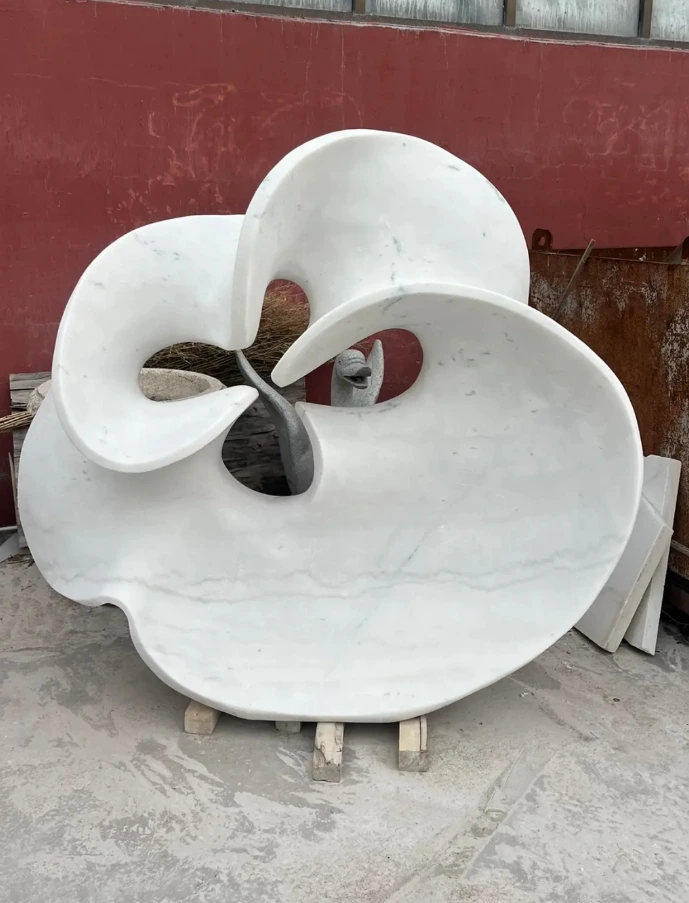 A monumental hand-carved natural white marble abstract sculpture featuring flowing organic lines and a central void. This piece exemplifies pure abstract art by prioritizing formal elements like shape, mass, and line over recognizable representation, creating a sophisticated visual experience for modern estate gardens or corporate plazas.