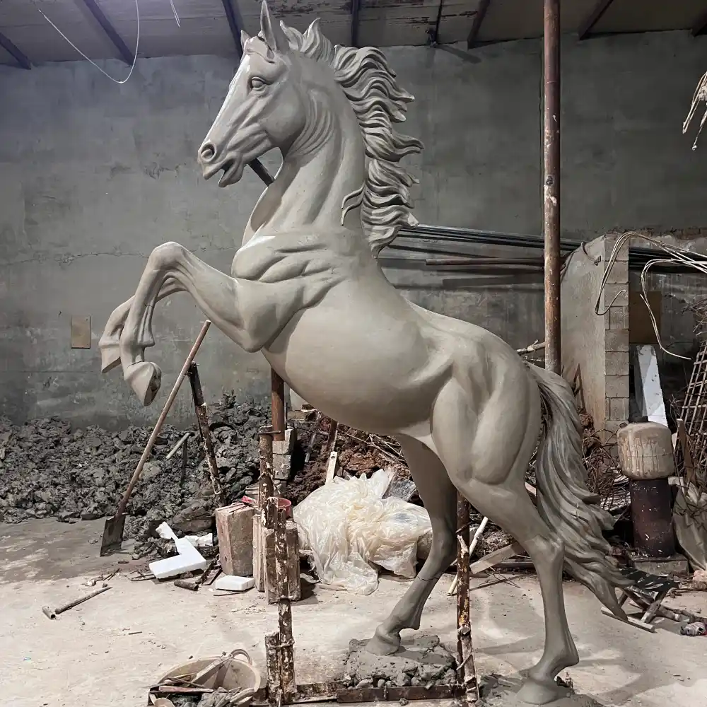 Full-size clay model of a rearing horse sculpture during the sculpting and proportion development stage.