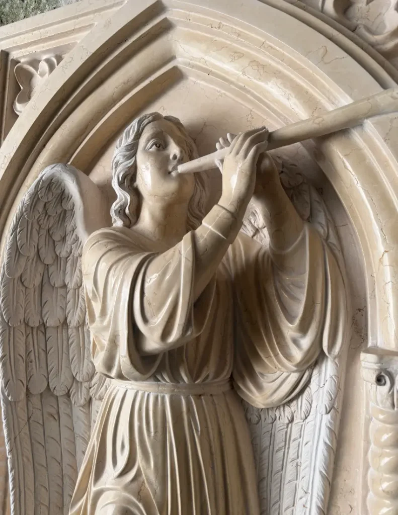Close-up of the finished St. Gabriel marble relief showing the face, raised horn, wings and garment details