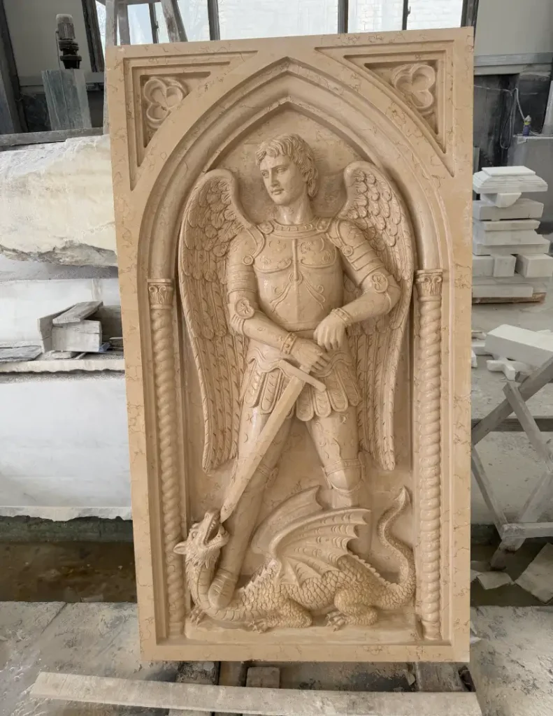 Front view of a St. Michael marble relief during detailed stone carving
