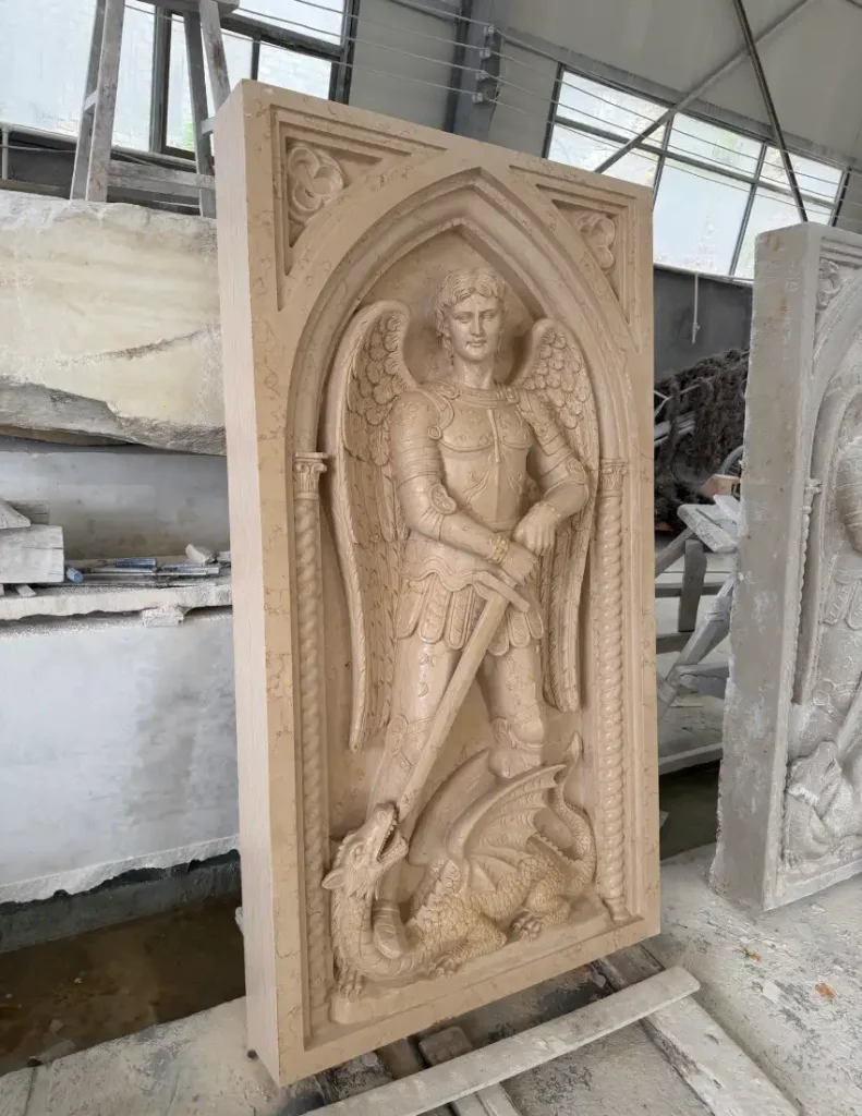 Side view of a St. Michael marble relief showing the carving depth and architectural frame