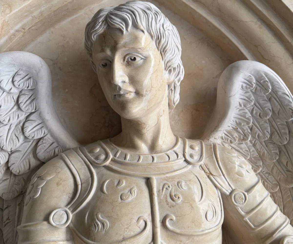 Close-up of the finished St. Michael marble relief showing the face, armor and carved wings