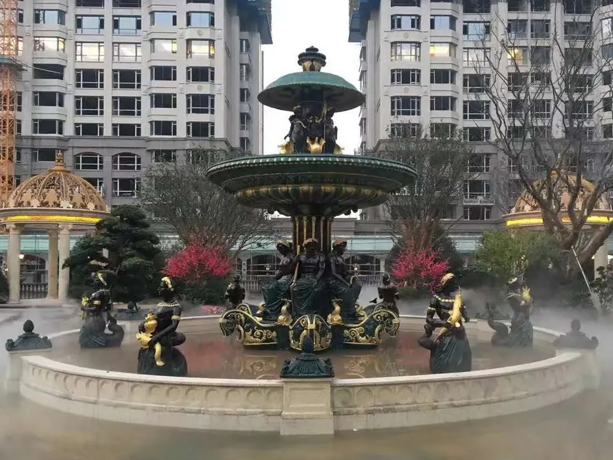 Large black and gold bronze figure fountain installed in a residential courtyard