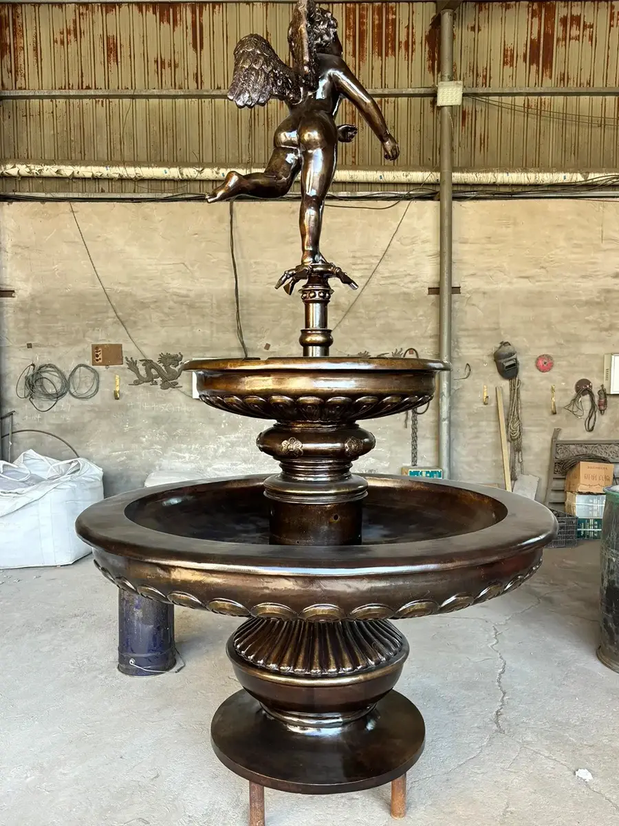 Full view of a bronze angel two-bowl fountain in the workshop