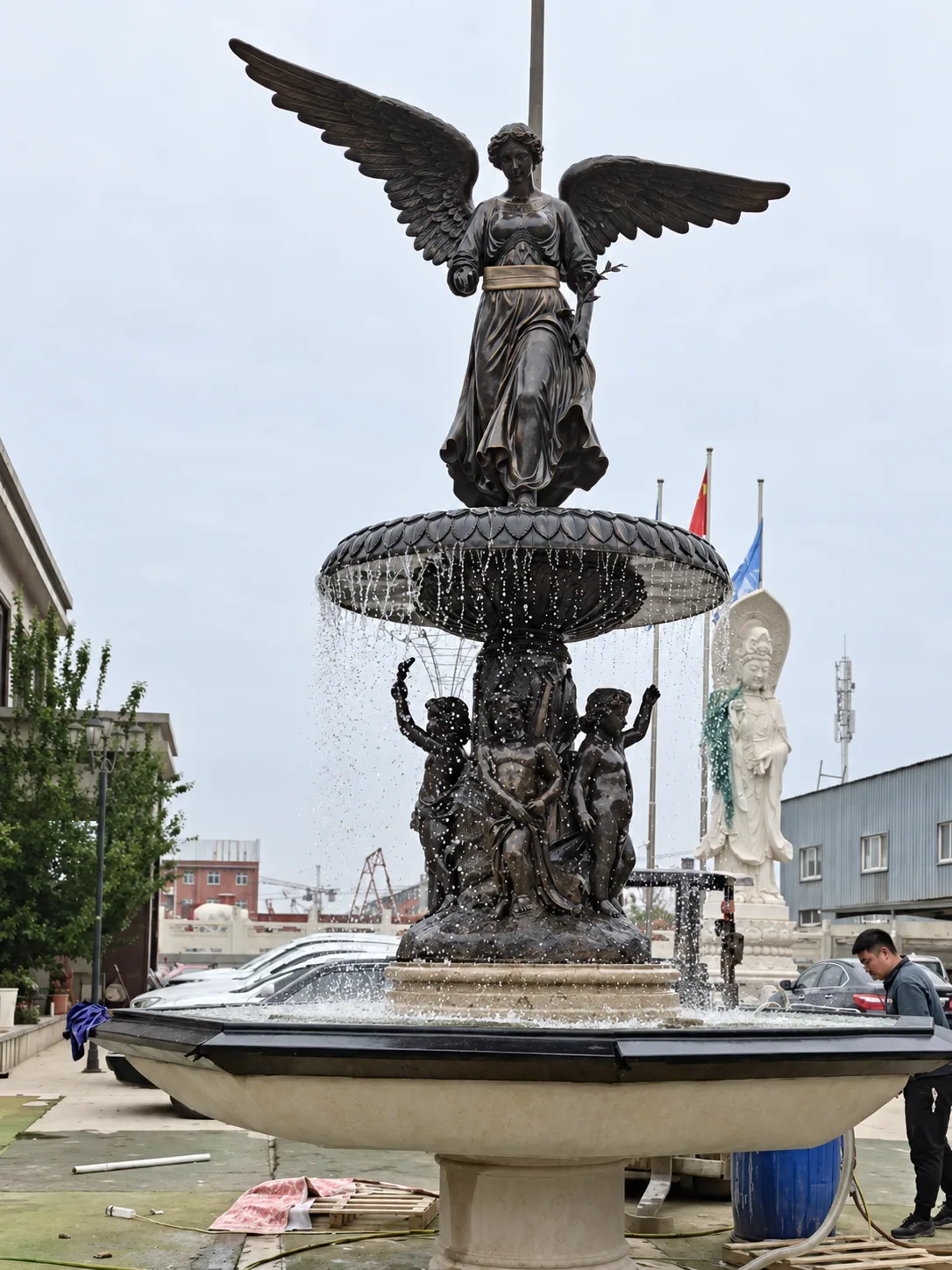 Winged bronze angel and cherub fountain running water during a factory test