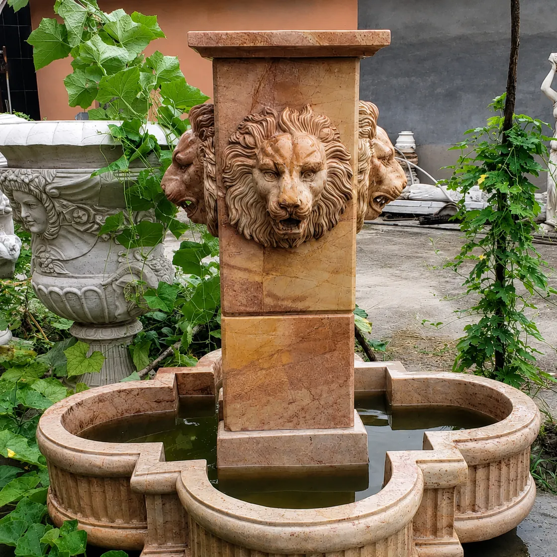 Close view of a carved lion head and stone basin detail for a custom fountain