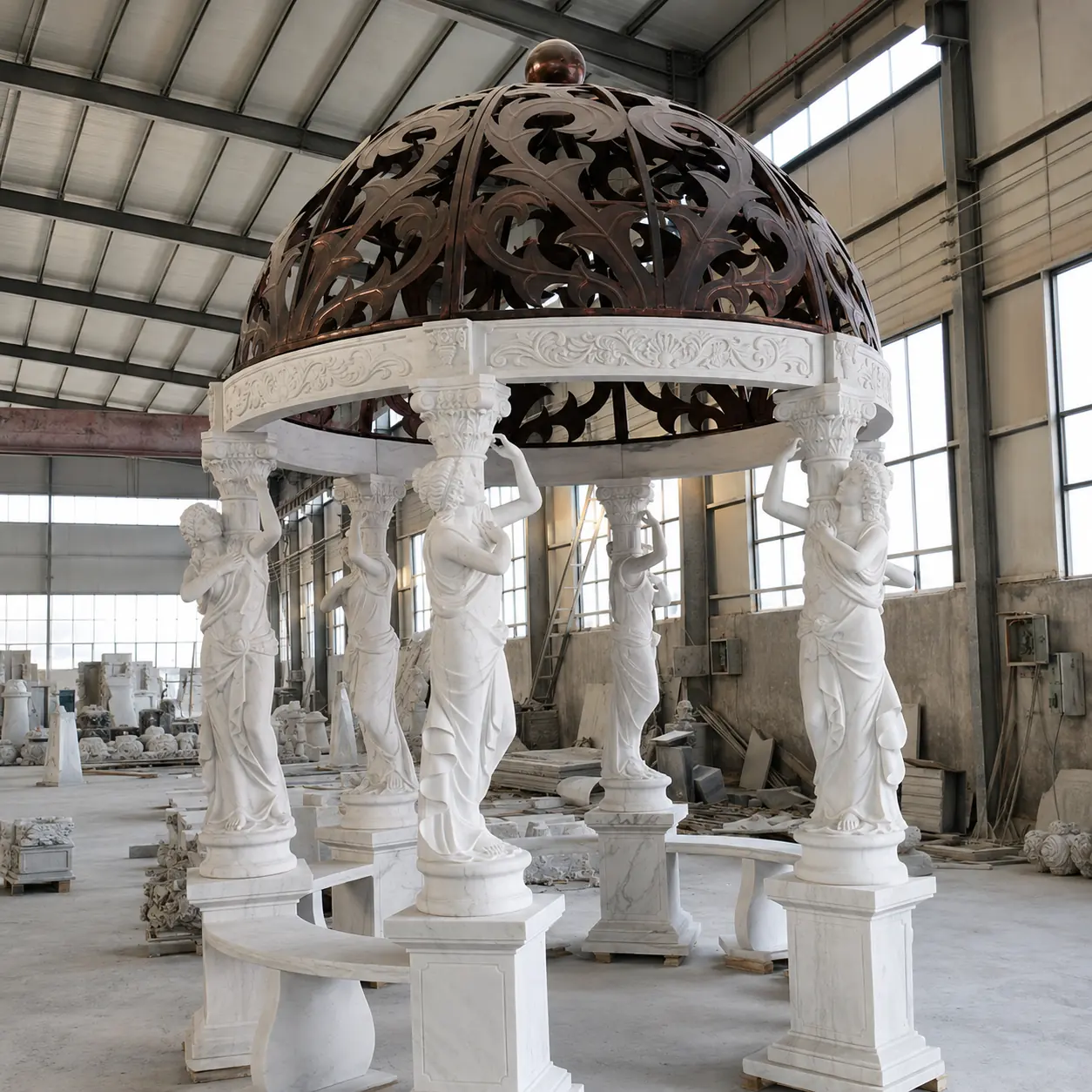 White marble caryatid gazebo with a bronze tone decorative metal dome at the factory
