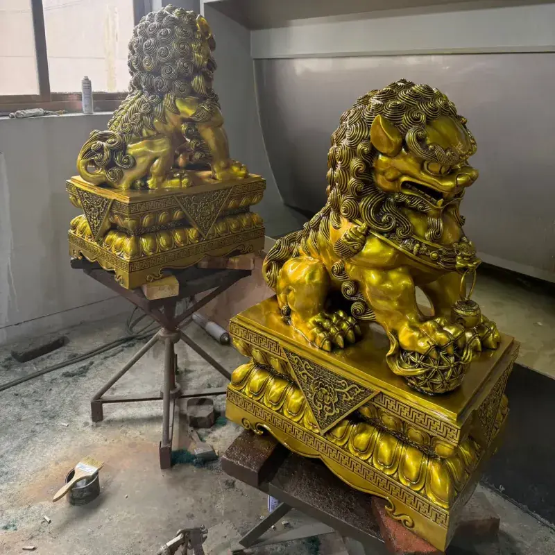 Side view of a gold-patina bronze Foo Dog statue pair showing body proportions