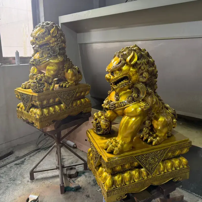 Three-quarter view of a gold-patina bronze Foo Dog statue pair
